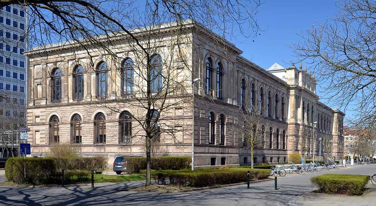 The sandstone Altgebäude of the Technische Universität Braunschweig with tall arched windows, seen on a clear spring day