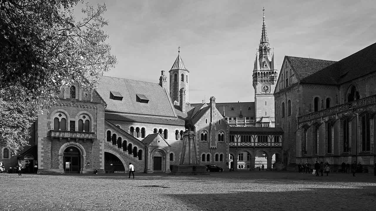 Burgplatz in Braunschweig with the Burg Dankwarderode, the bronze lion on its plinth and the cathedral at the right edge of the square