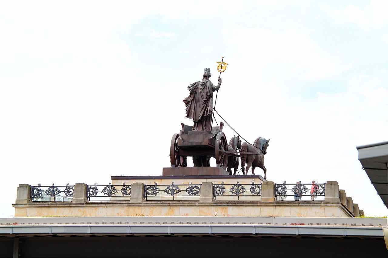 The bronze Quadriga with a charioteer and four horses on the roof of the Braunschweig Schloss against a pale sky
