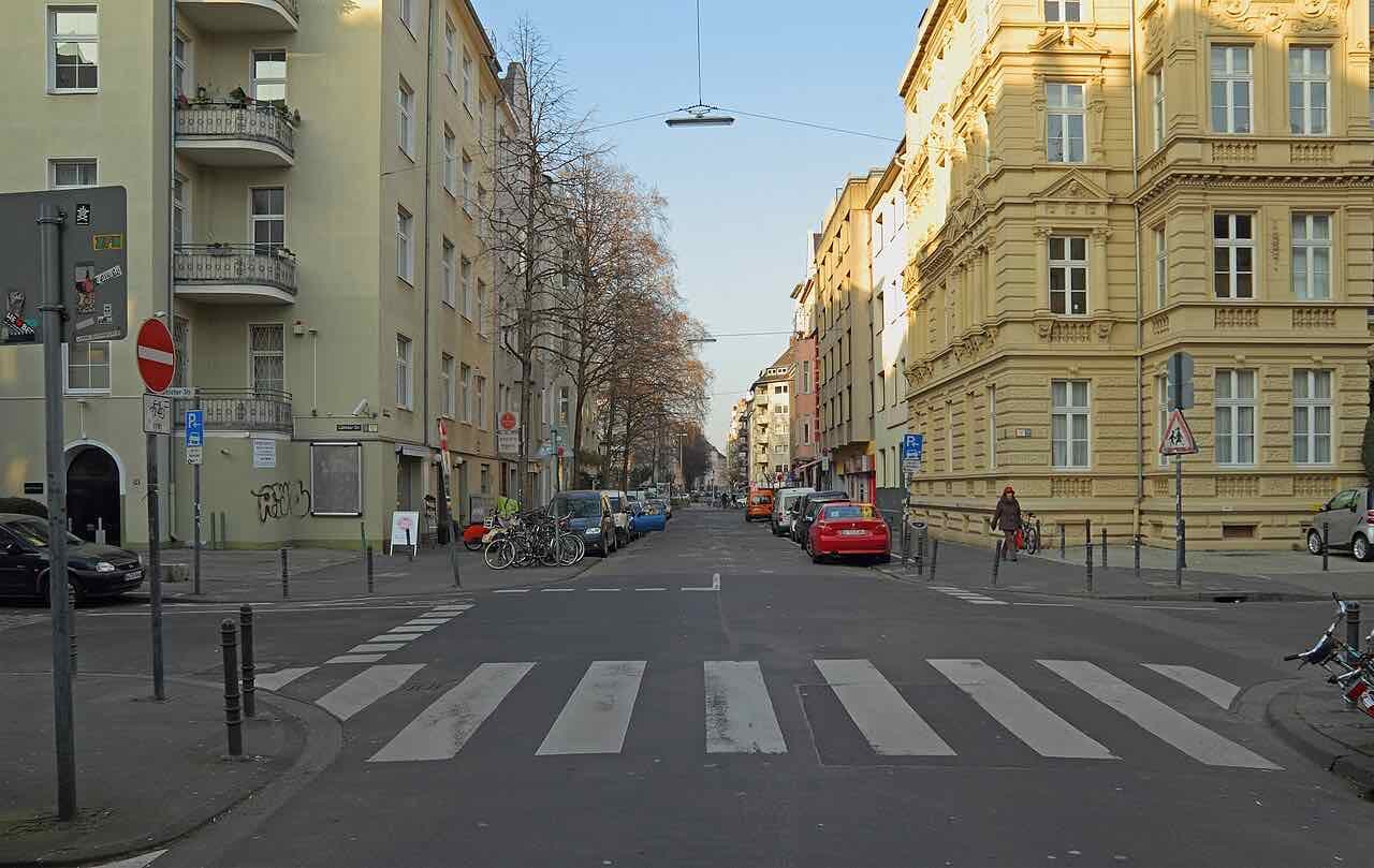 A street crossing in the Belgisches Viertel in Cologne with shopfronts and cafes