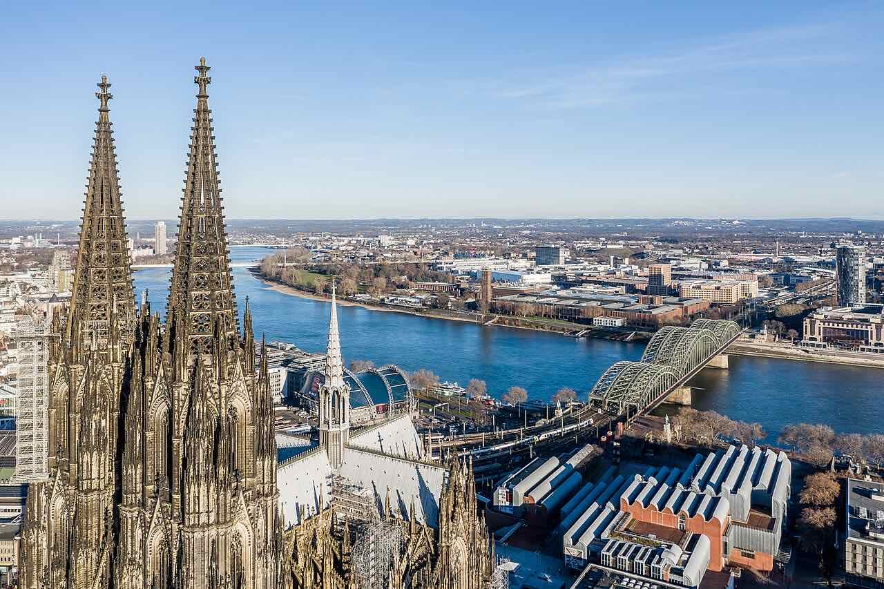 The two spires of Cologne Cathedral with the Rhine and the Hohenzollern Bridge behind them