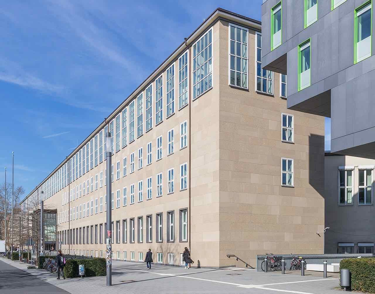 The main building of the University of Cologne seen from the south, with a long stone facade and a tower