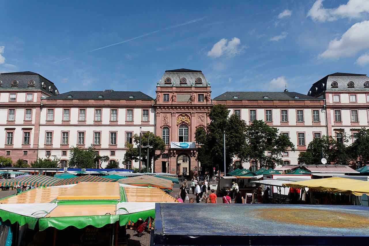 The pink and white Residenzschloss in Darmstadt behind market stalls on the Marktplatz under a blue sky