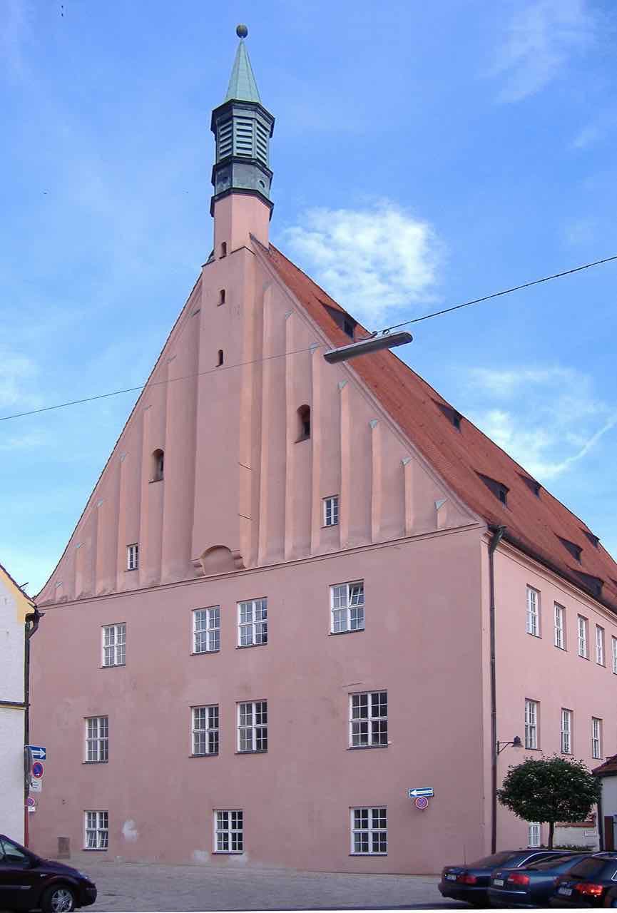 The tall pink gabled building of the Hohe Schule, the main building of the former Ingolstadt university, with a small green-roofed turret on top