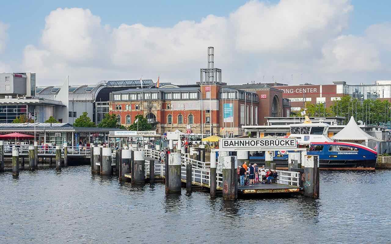The Bahnhofsbrücke ferry pier next to Kiel central station, with a blue and red fjord ferry waiting at the landing stage