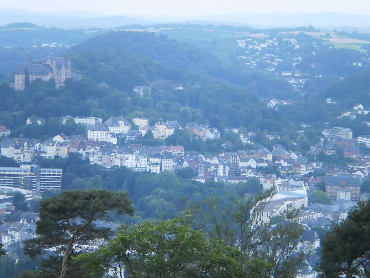 Marburg seen from the heights across the Lahn valley, with the old town houses in the valley and the castle on its hill at the upper left
