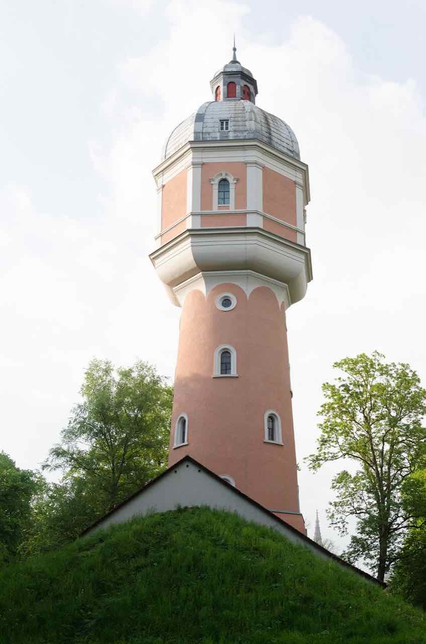The octagonal water tower of Neu-Ulm standing on a grassy rampart of the old fortress under a cloudy sky