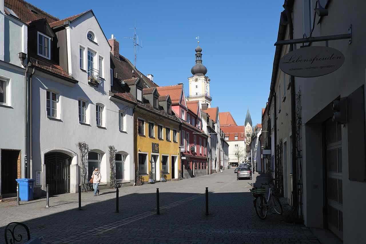 The Judengasse in Weiden, a quiet cobbled street with colourful townhouses and the church tower at the end