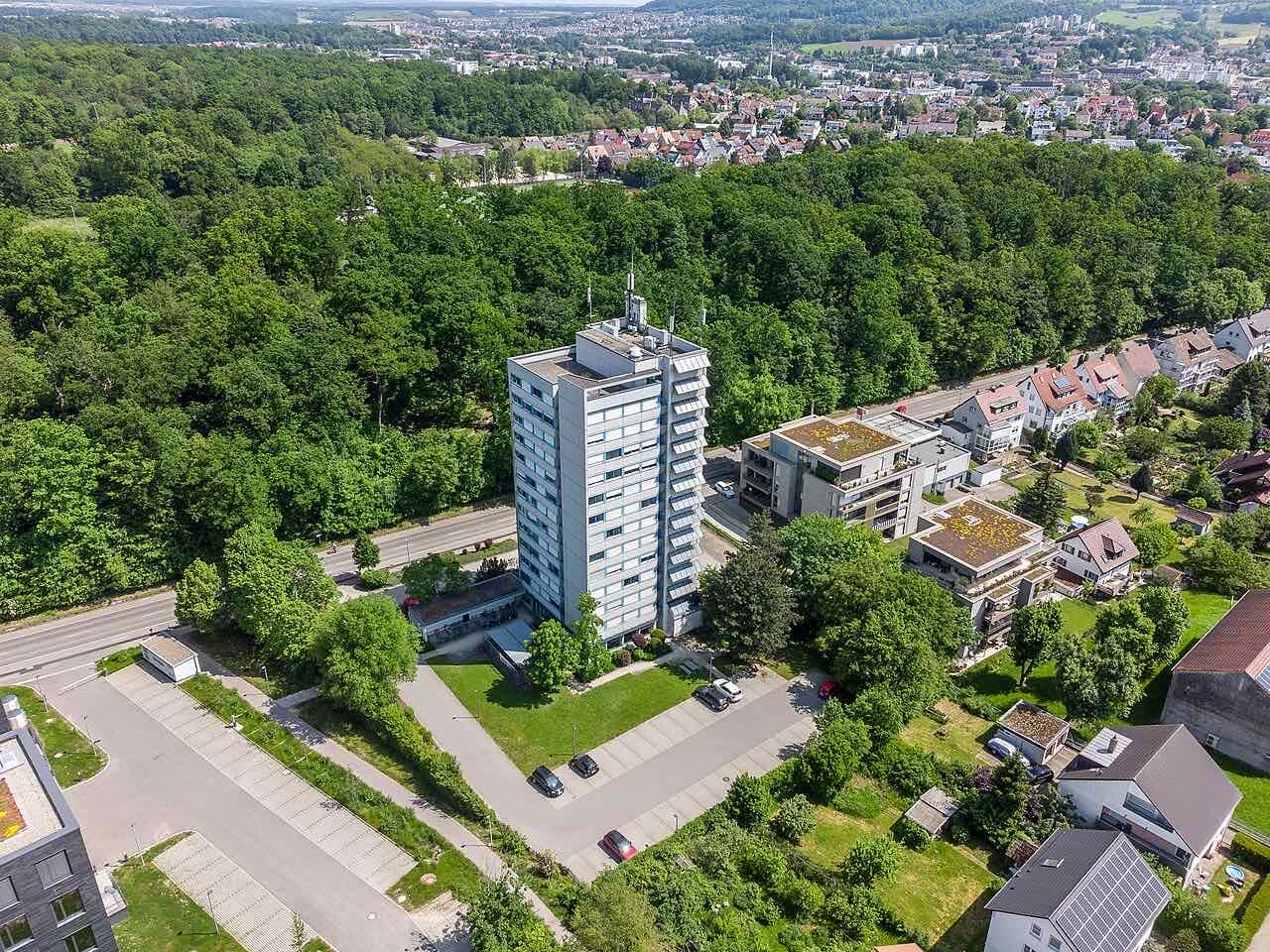 A tower building of Aalen University seen from a balloon with trees and sports fields around it
