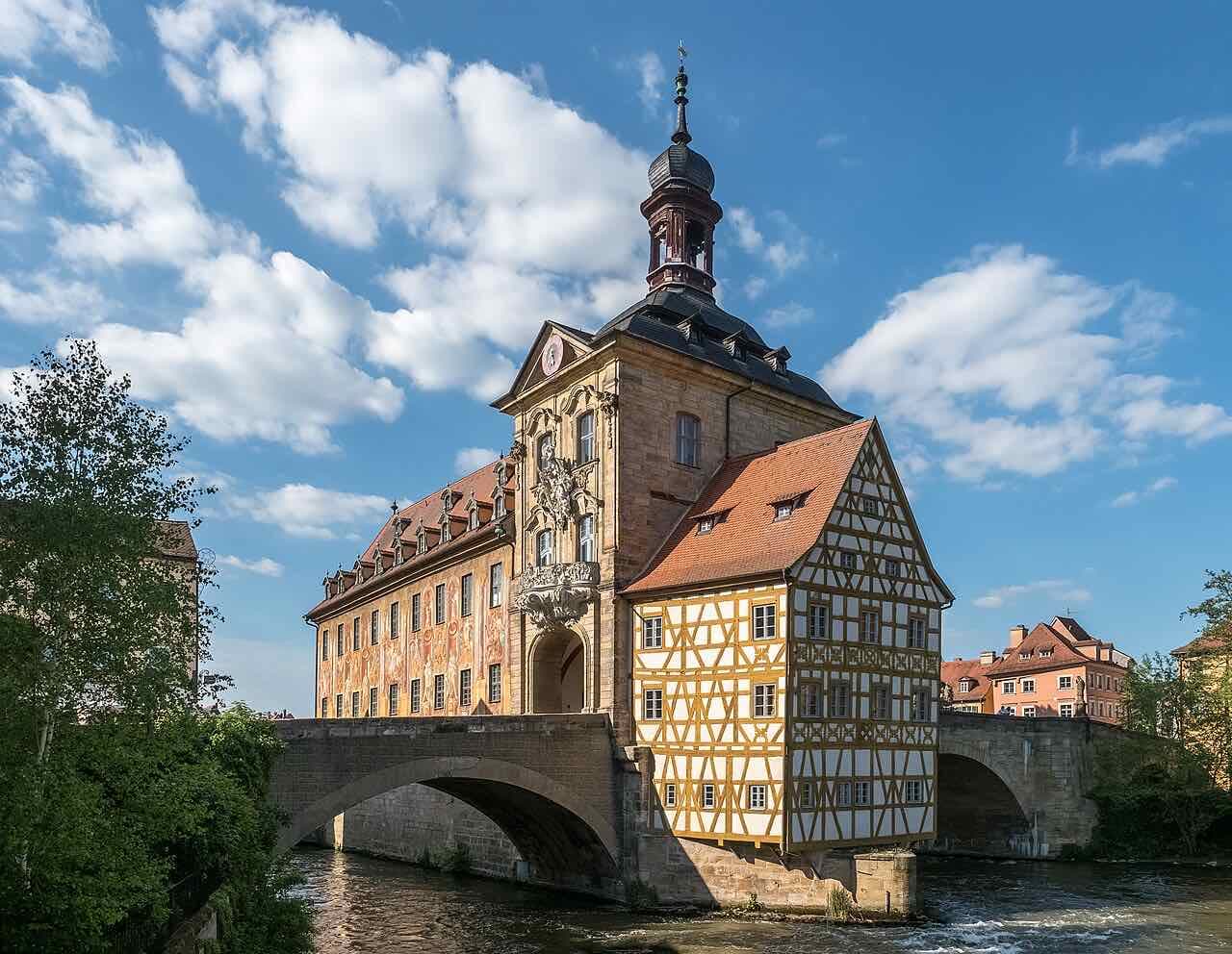 The Altes Rathaus, a painted half-timbered town hall standing on an artificial island in the river between two bridges
