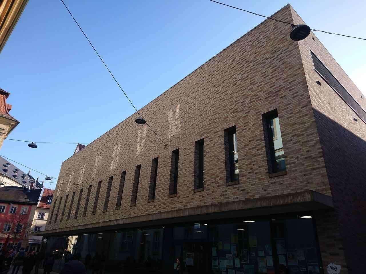 The brick facade of the Mensa Austraße in the old town, with notice boards at street level