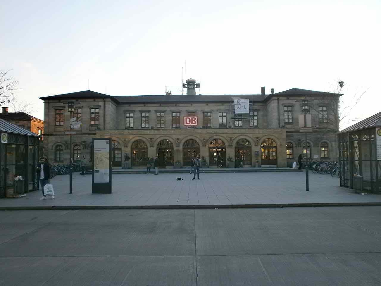 The sandstone front of Erlangen main station with the DB sign and bicycle racks at both ends