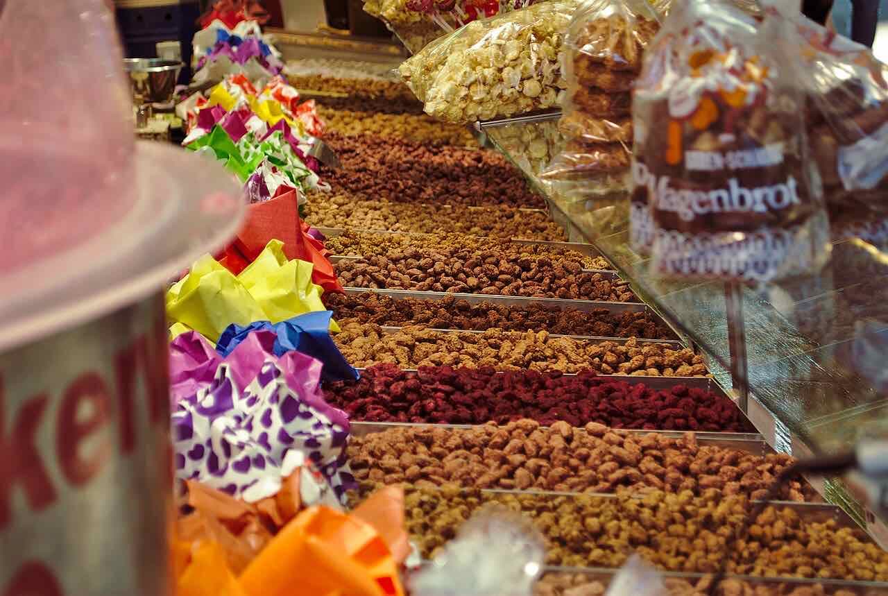 A long stall of roasted almonds and sweets in different colours at the Bergkirchweih