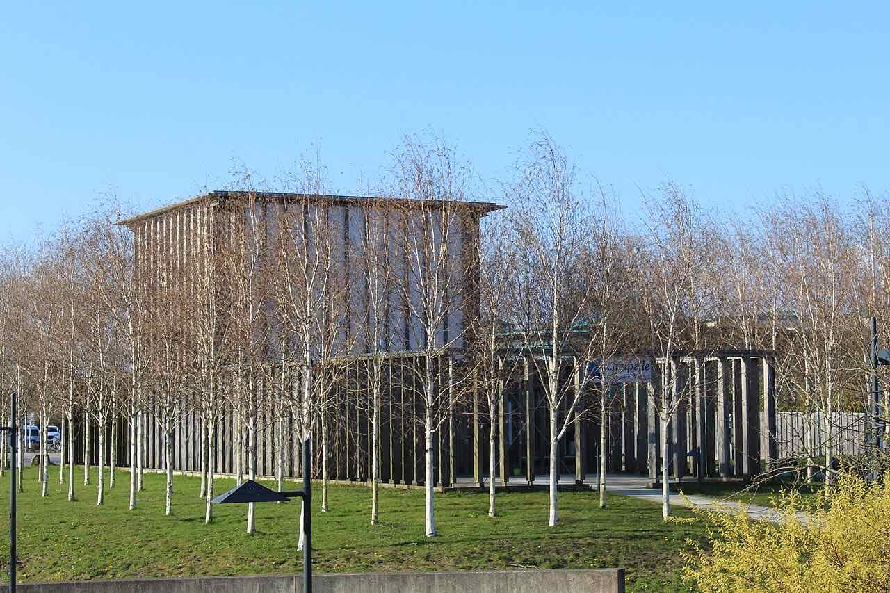 The Campelle, the university chapel on the Flensburg campus, a timber-clad building seen through young birch trees on a spring day