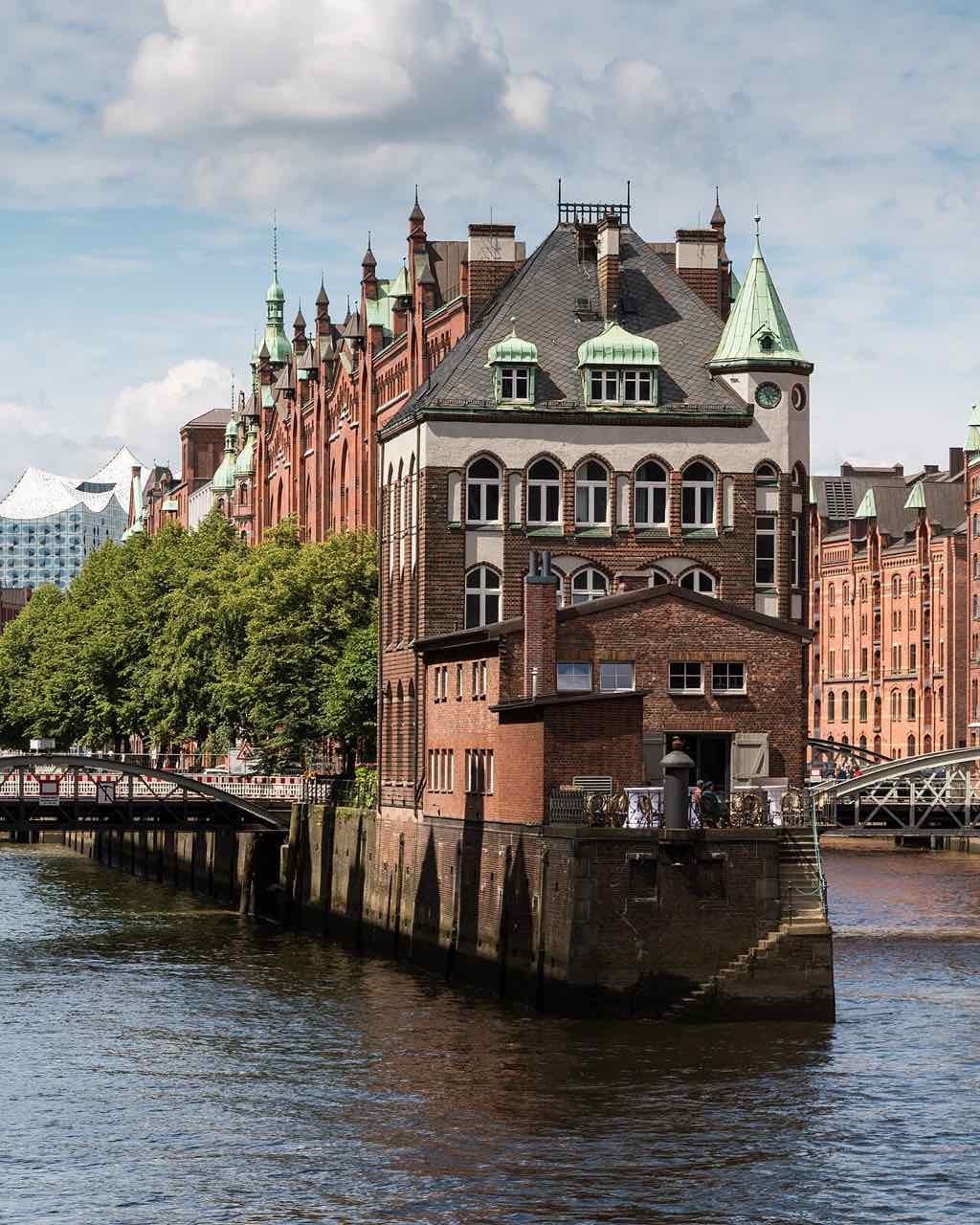 The red-brick Wasserschloss warehouse in the Speicherstadt standing on the canal between two fleets