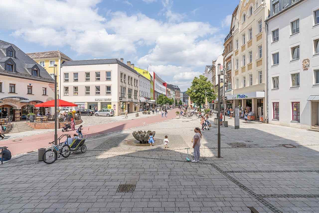 The pedestrian old town of Hof on a summer day, with a fountain, cafe terraces and shops