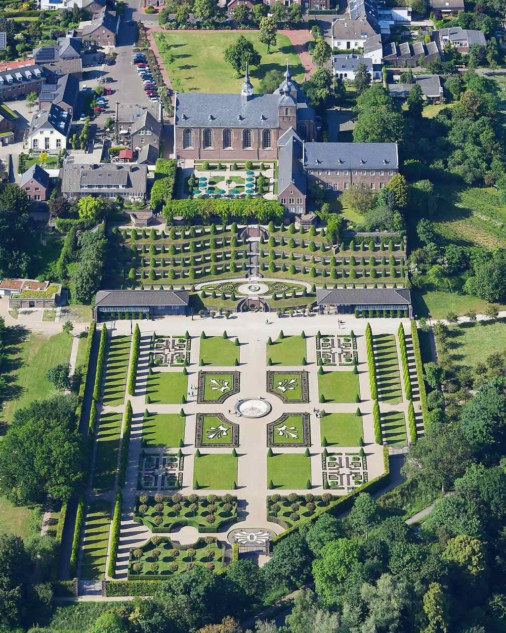 An aerial view from the south of Kamp Abbey and its gardens: the abbey church and cloister at the top, the terraces in the middle and formal garden beds in front