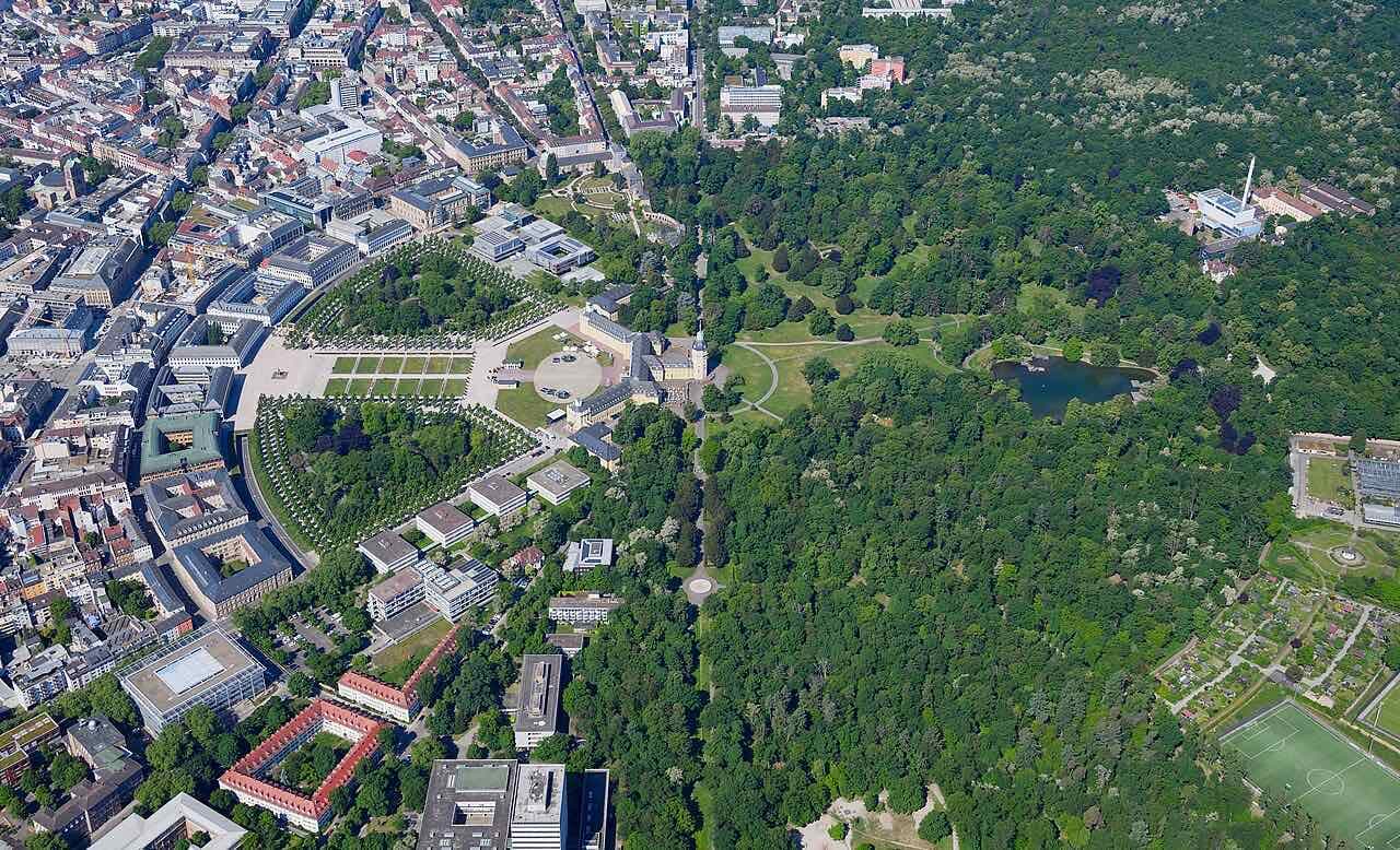 Aerial view of Karlsruhe with the palace in the middle, the dense city blocks on the left and the dark green palace garden and forest on the right