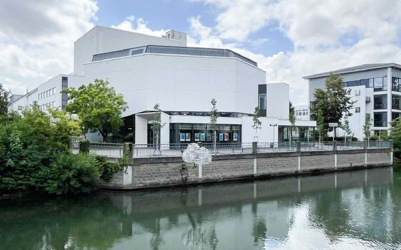 The Stadttheater Lippstadt, a modern concrete and glass building with a wide entrance, in June 2024