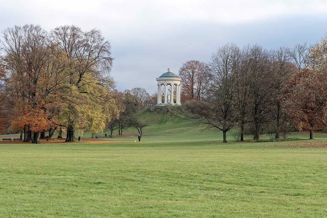 The Monopteros, a small round temple on a hill in the English Garden in Munich, seen across a meadow