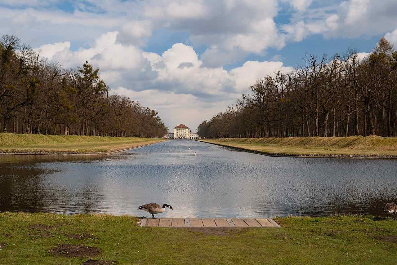 The long white front of Nymphenburg Palace in Munich under a blue sky
