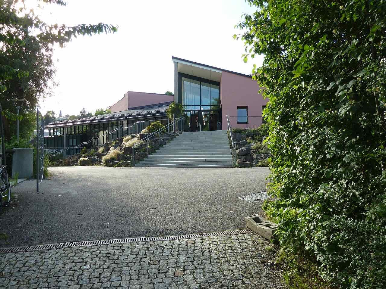 The Audimax, the main lecture hall, with a glass entrance at the top of wide steps and rock plantings beside them