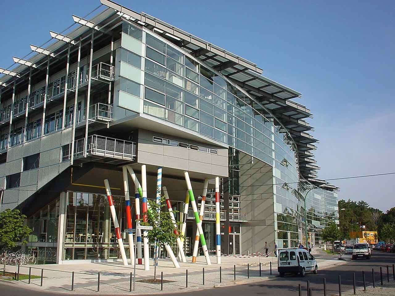 The glass and steel main building of the Film University Babelsberg with colourful striped columns at the entrance, on Marlene-Dietrich-Allee