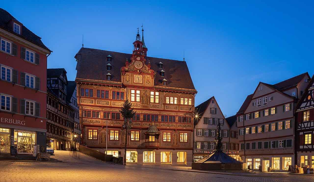 The Tübingen market square at dusk with the town hall and the half-timbered houses around it lit up